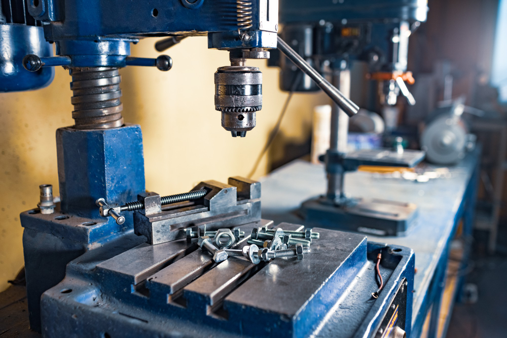 Metal chrome bolts and nuts on drilling machine at the workplace